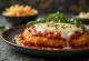 Chicken parmigiana served with pasta and fresh basil
