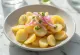 Sallatë patatesh e freskët me patate të ziera, qepë të kuqe dhe majdanoz të freskët.